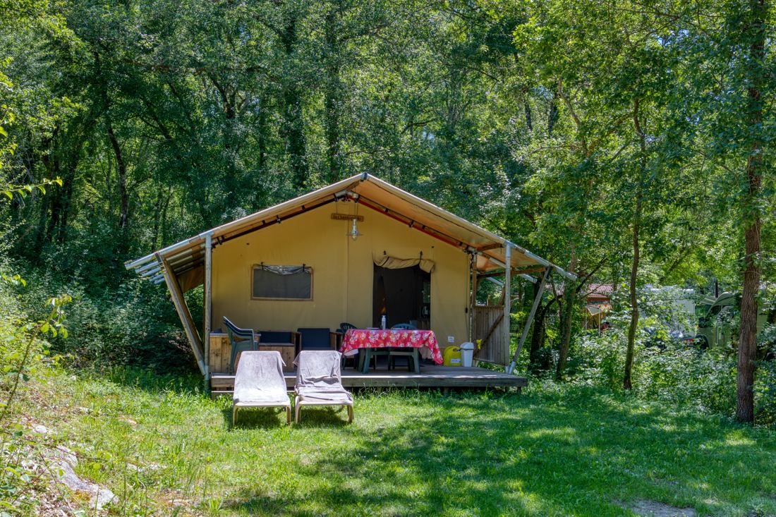 Safaritent met houten terras tussen de bomen